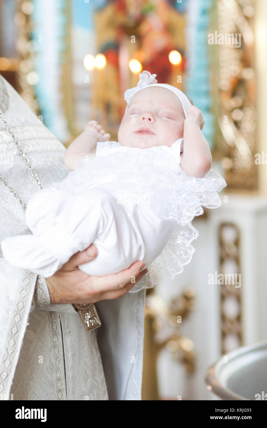 Priester Holding Baby Mädchen in der Kirche Stockfoto