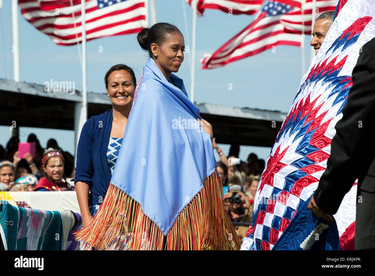 First Lady der USA Michelle Obama trägt einen Schal zu ihr präsentiert von Native American Tribe Vorsitzender Dave Archambault II während die Kanonenkugel Flag Tag Feier an der Standing Rock Sioux Tribe Reservierung Cannon Ball Powwow Gründen Juni 13, 2014 in Cannon Ball, North Dakota. Stockfoto