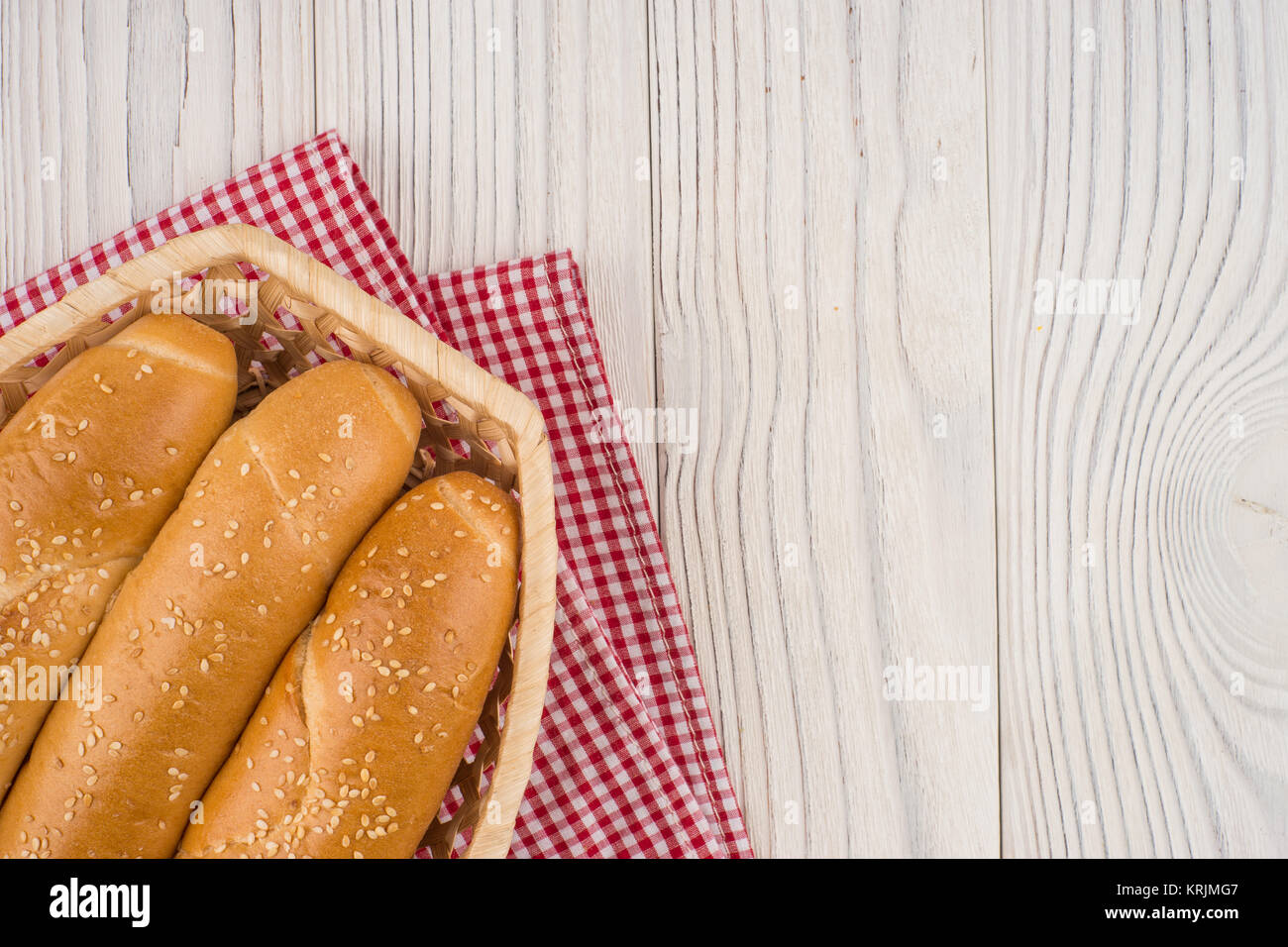 Brötchen in einem Weidenkorb auf alten Holztisch. Stockfoto