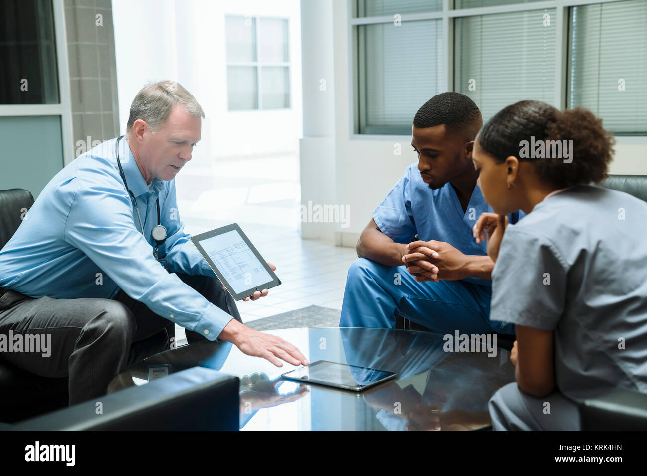 Arzt und Krankenschwestern diskutieren digital Tablet Stockfoto
