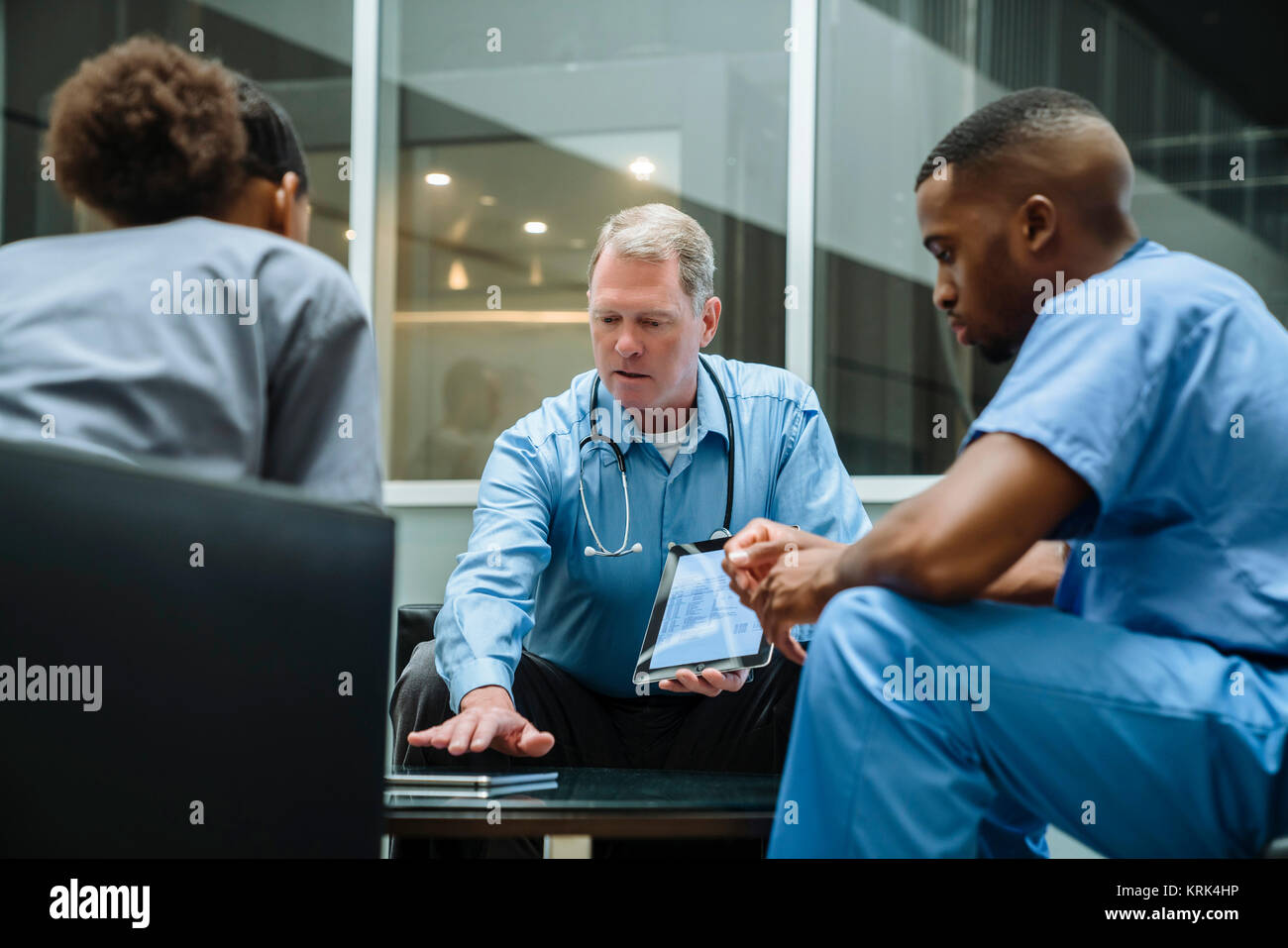 Arzt und Krankenschwestern diskutieren digital Tablet Stockfoto