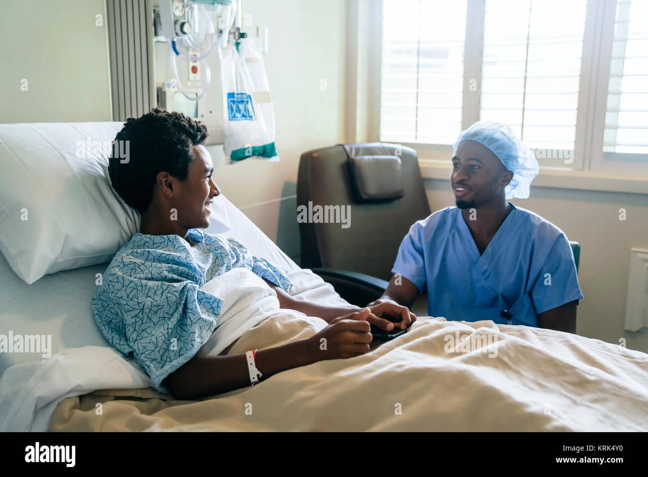 Schwarze Krankenschwester im Gespräch mit Junge im Krankenhaus Stockfoto