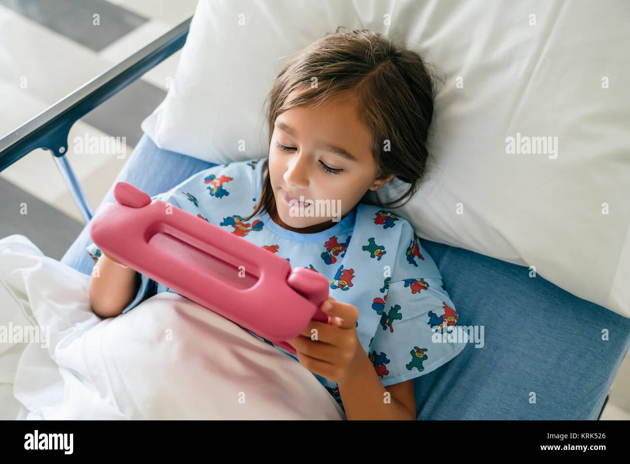 Gemischte Rasse Mädchen mit digitalen Tablette im Krankenhausbett Stockfoto