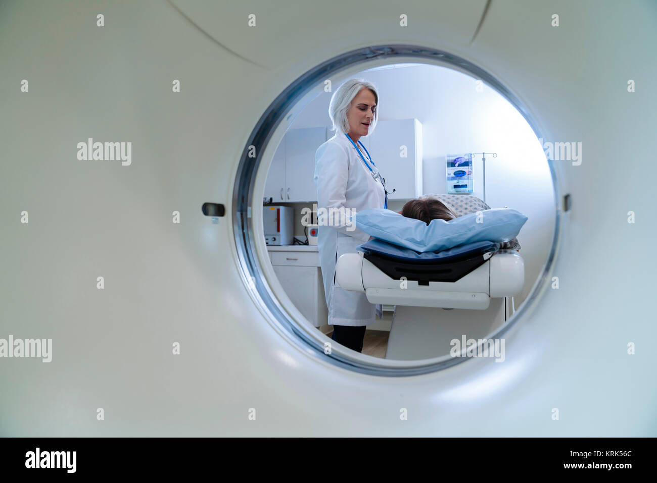Kaukasische Arzt im Gespräch mit Patienten in der Nähe des Scanners Stockfoto