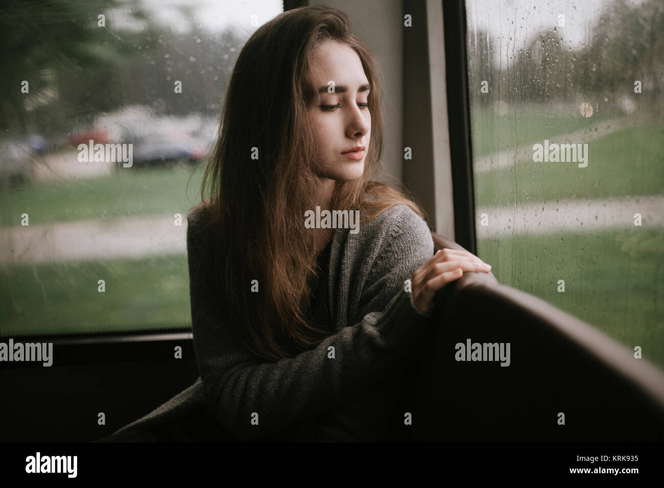 Nachdenklich kaukasische Frau sitzt auf der Bus im Regen Stockfoto
