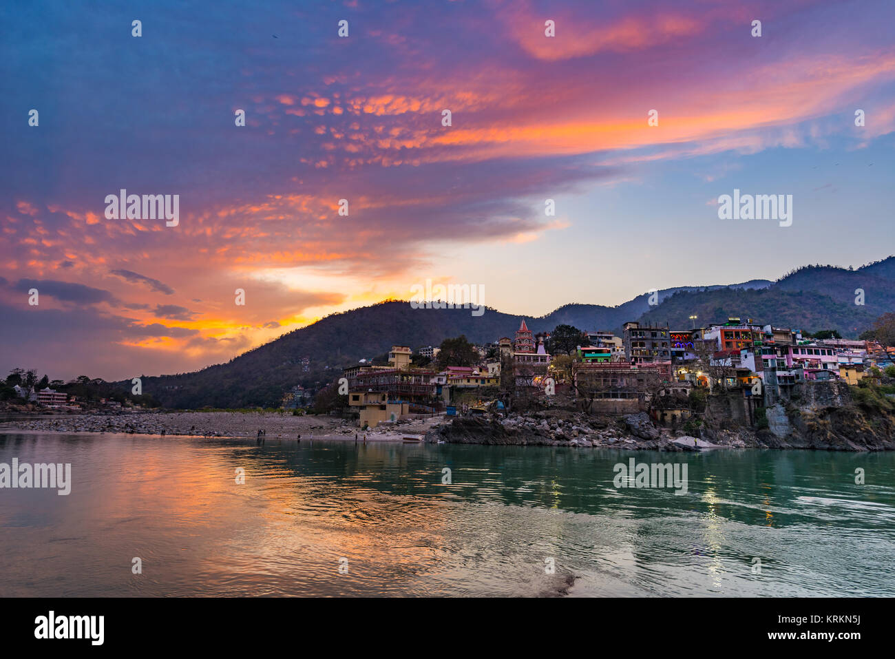 Zeit in Rishikesh, heilige Stadt der Abenddämmerung und Reiseziel in Indien. Bunter Himmel und Wolken reflektieren über den Ganges. Stockfoto