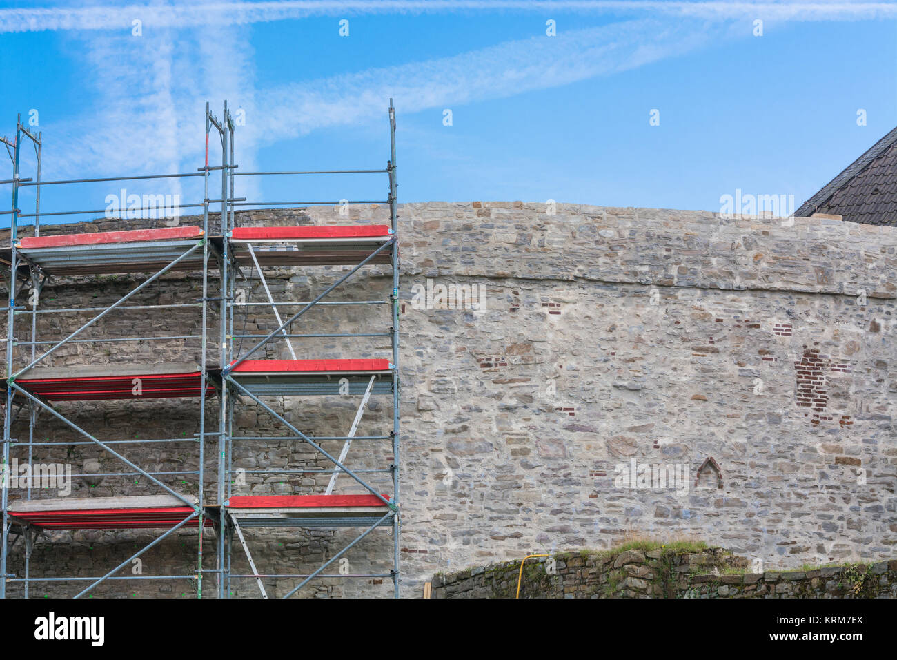 Alte Burgmauer mit baugerüst vor blauen Himmel. Stockfoto