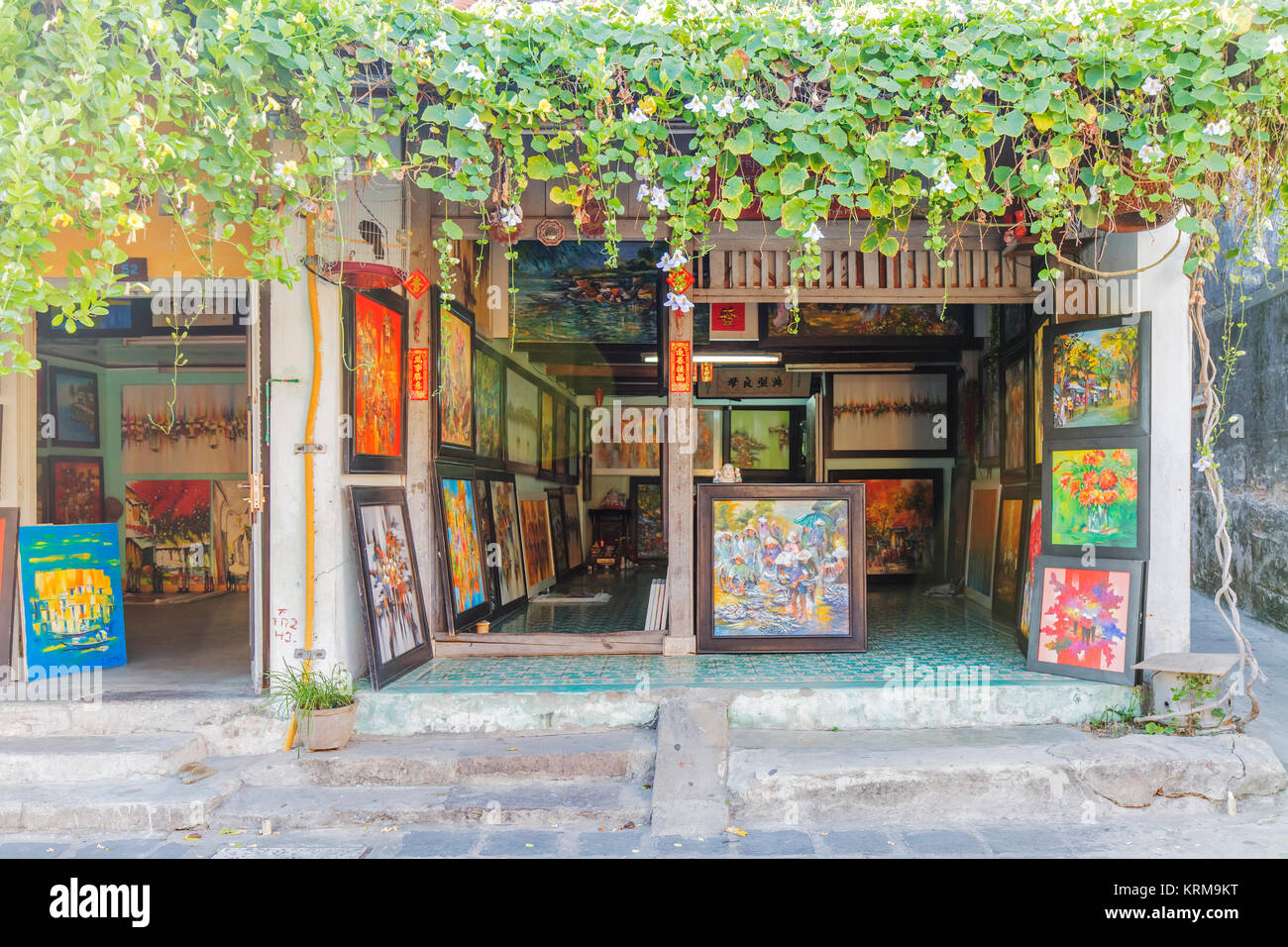 Shop Verkauf von Gemälden auf der alten Stadt Hoi An, Vietnam. Schöne alte, historische Hoi An Startseite mit gelben Wänden und Pflanzen klettern bis die Wände Stockfoto