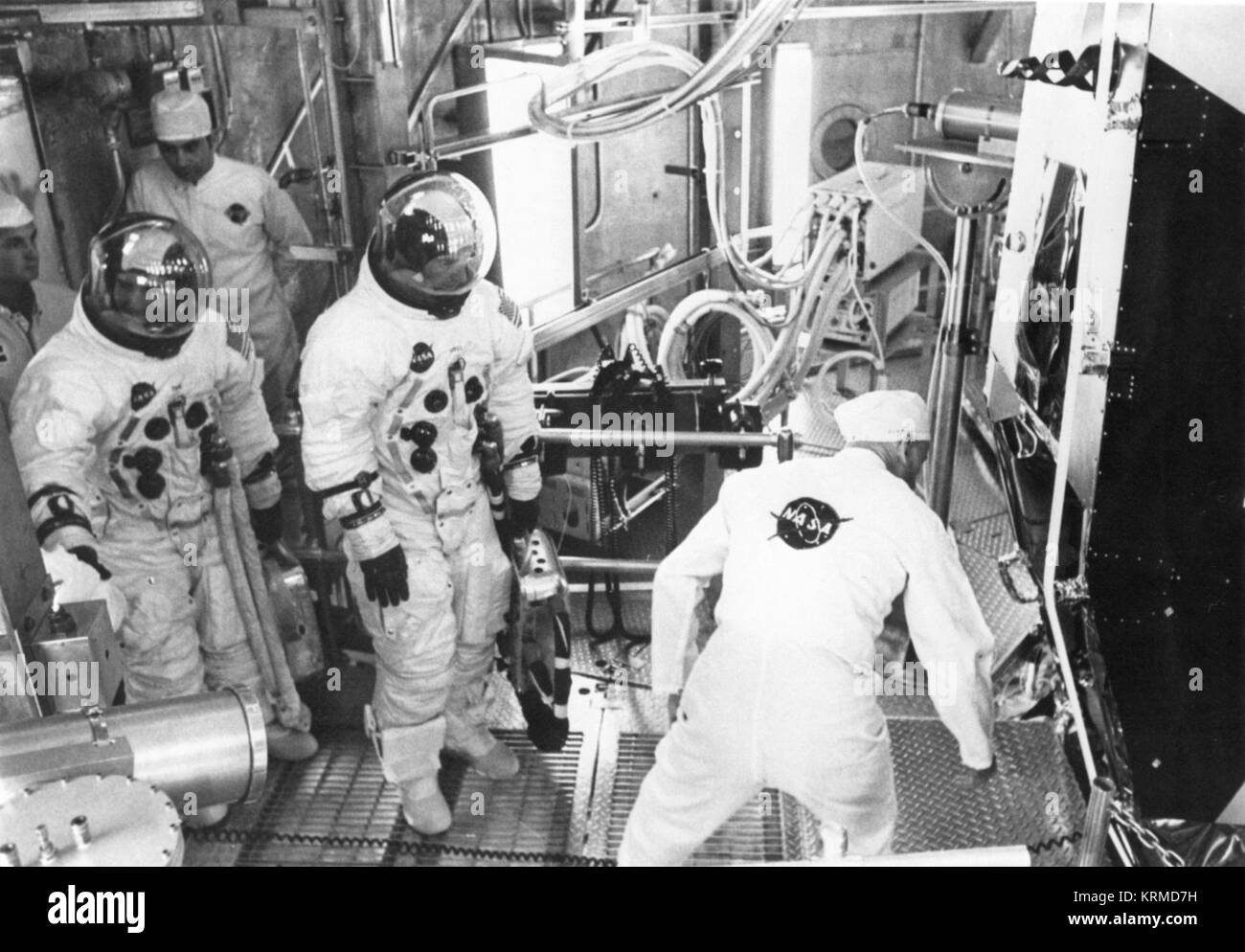Anzug Techniker Joe Schmidt unterstützt backup Apollo 11 Lunar Module pilot Fred W. Haise, Jr., Links, und James A. Lovell, Backup crew Befehlshaber in Lunar Module für bemannte Höhe laufen Stockfoto