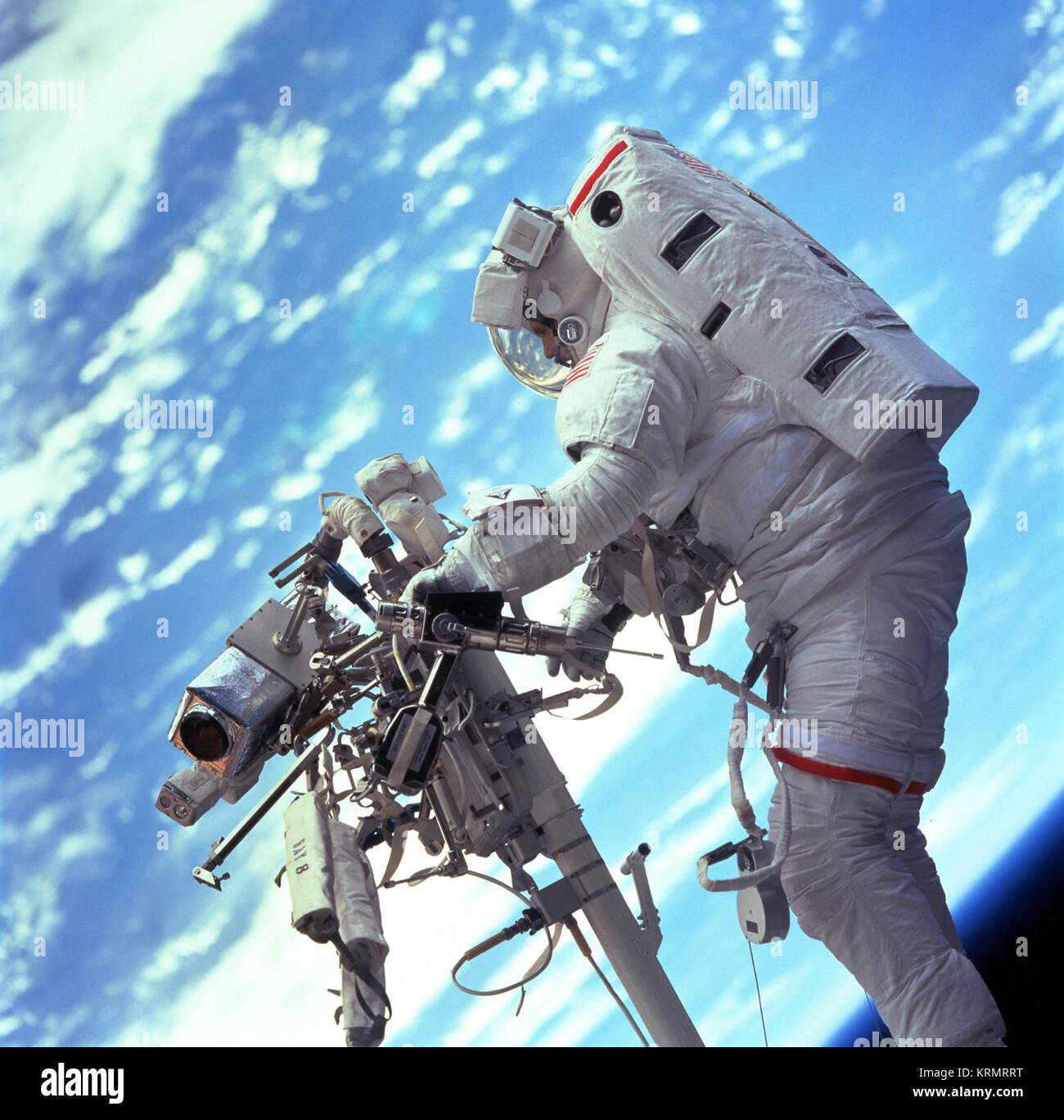 STS-047 103-701 (19-27 Dezember 1999) - - - Astronaut Steven L. Smith, Nutzlast Commander, holt ein Power Tool beim Stehen auf dem Mobile Fuß Zurückhaltung am Ende der Remote Manipulator System (RMS). Viele der Werkzeuge erforderlich, das Hubble Space Teleskop Service sind auf dem Handlauf der RMS in der Fotografie sichtbar angebracht gespeichert. STS-103 Shuttle Mission Imagery (6377207601) Stockfoto