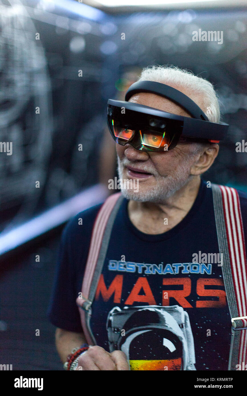 Apollo 11 Astronaut Buzz Aldrin versucht Microsoft HoloLens Realität Headsets während eine Vorschau auf das neue Ziel gemischt: Mars Erfahrung im Kennedy Space Center Visitor Komplex. Reiseziel: Mars gibt Gästen die Möglichkeit, zu "besuchen" mehrere Standorte auf dem Mars mit echten Bildern aus Neugier der NASA Mars Rover. Auf OnSight, ein Werkzeug, das von Jet Propulsion Laboratory der NASA in Pasadena, Kalifornien, erstellt auf der Grundlage der Erfahrung bringt die Gäste zusammen mit einem holographischen Version von Aldrin, wie Sie, um über das Headset zu Mars geführt werden. Photo Credit: NASA/Charles Babir Apollo 11 Astronaut Buzz Aldrin tri Stockfoto