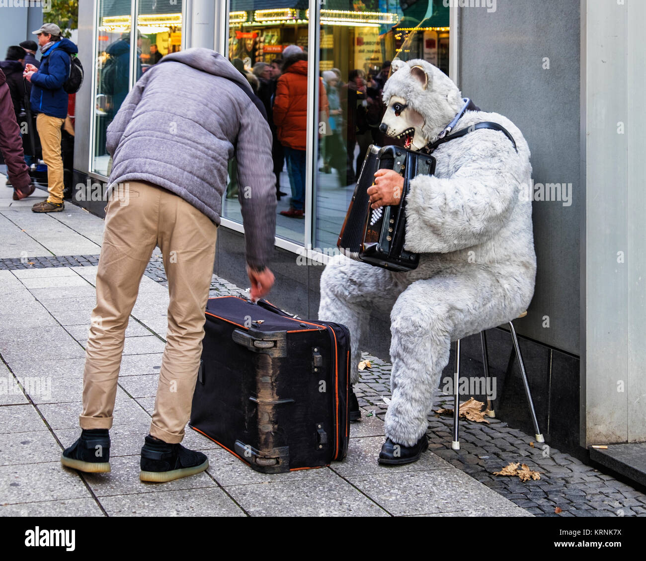 Frankfurt, Deutschland. Passanten Geld zu geben Mann spielt accorcdion in tragen Kostüme Anzug Stockfoto