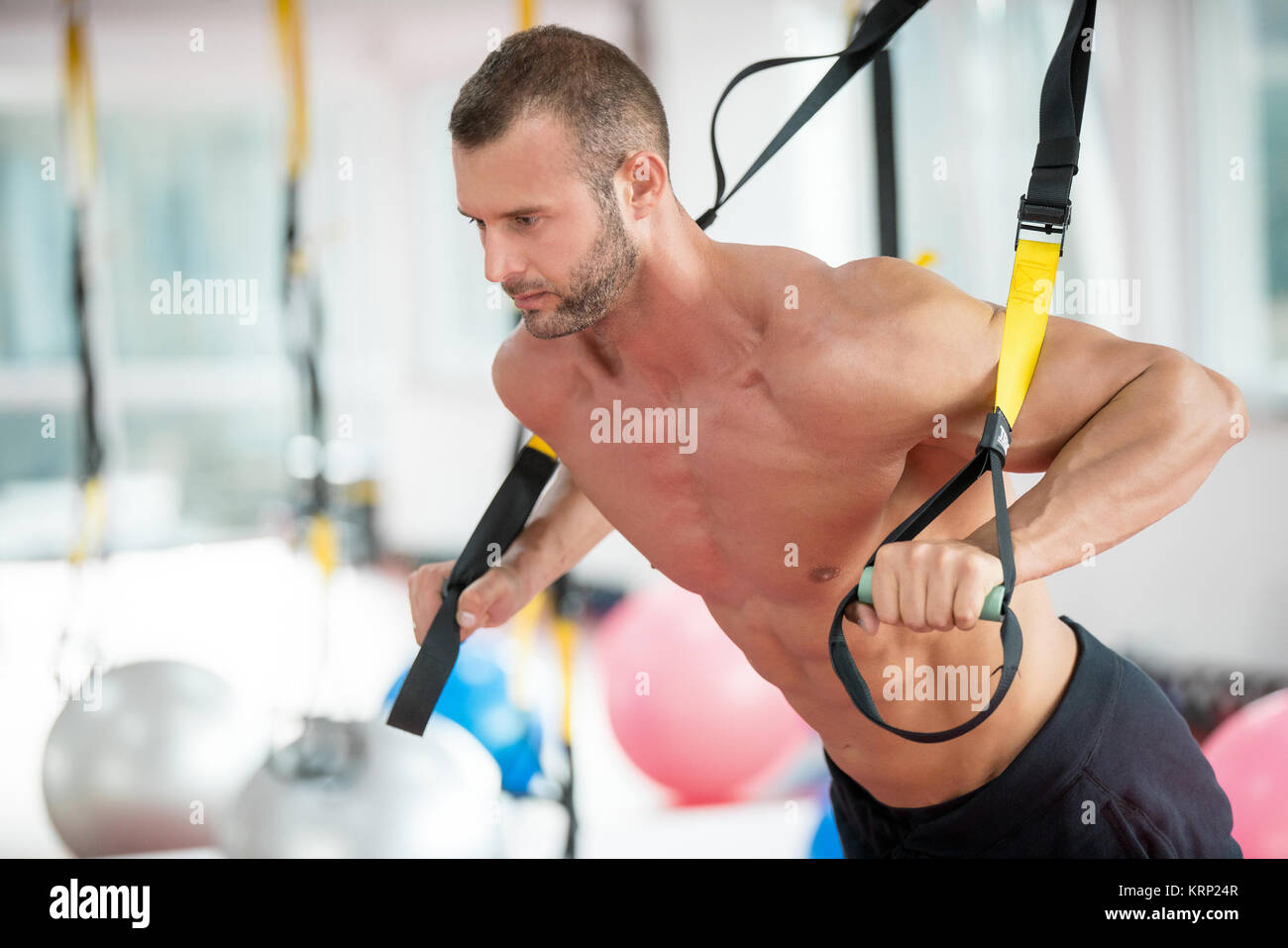 Kerl, Push-ups training Arme mit trx fitness Bänder in der Turnhalle Konzept workout gesunder Lebensstil Sport Stockfoto