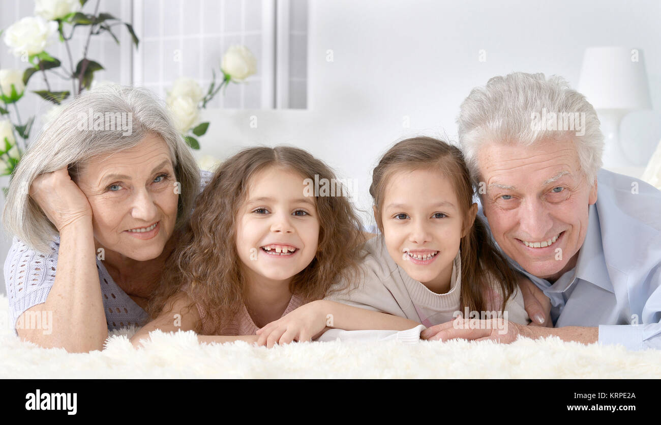 Gerne älteres Paar mit Enkel zu Hause Stockfoto