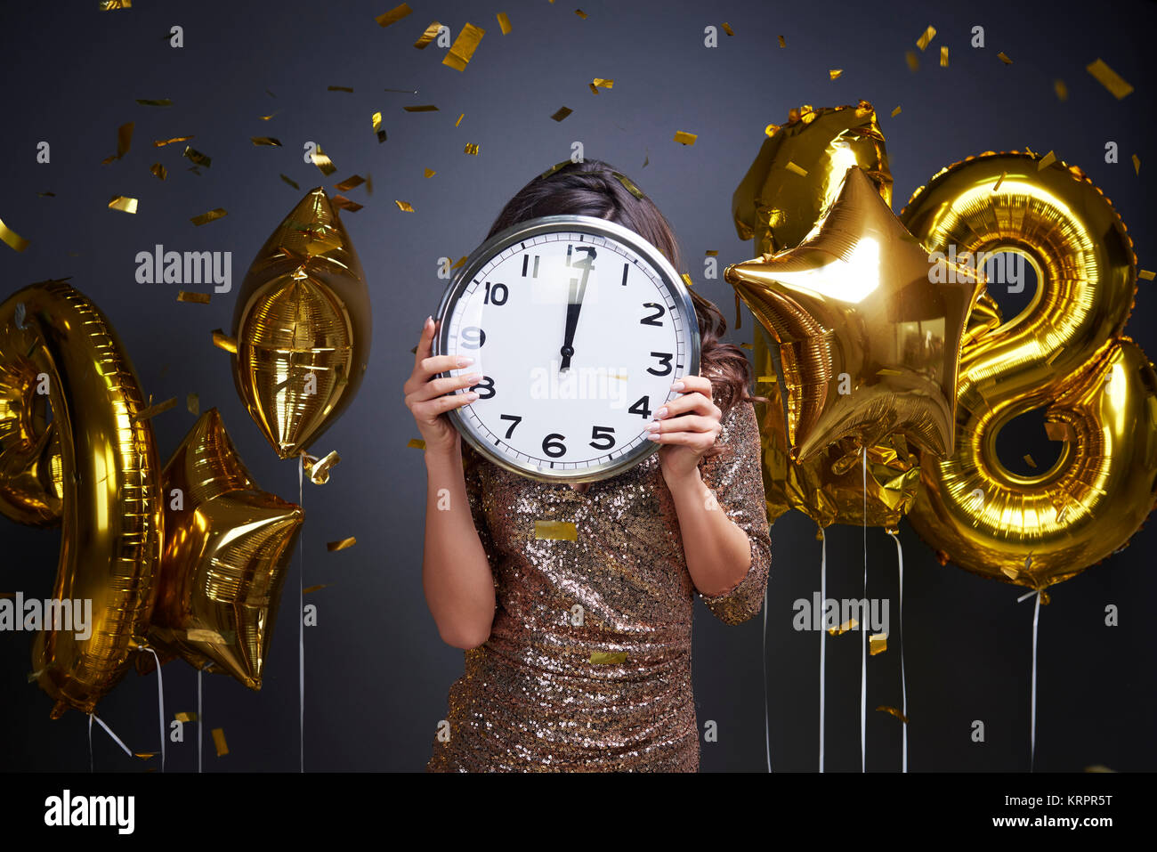 Frau Holding Uhr vor ihrem Gesicht Stockfoto