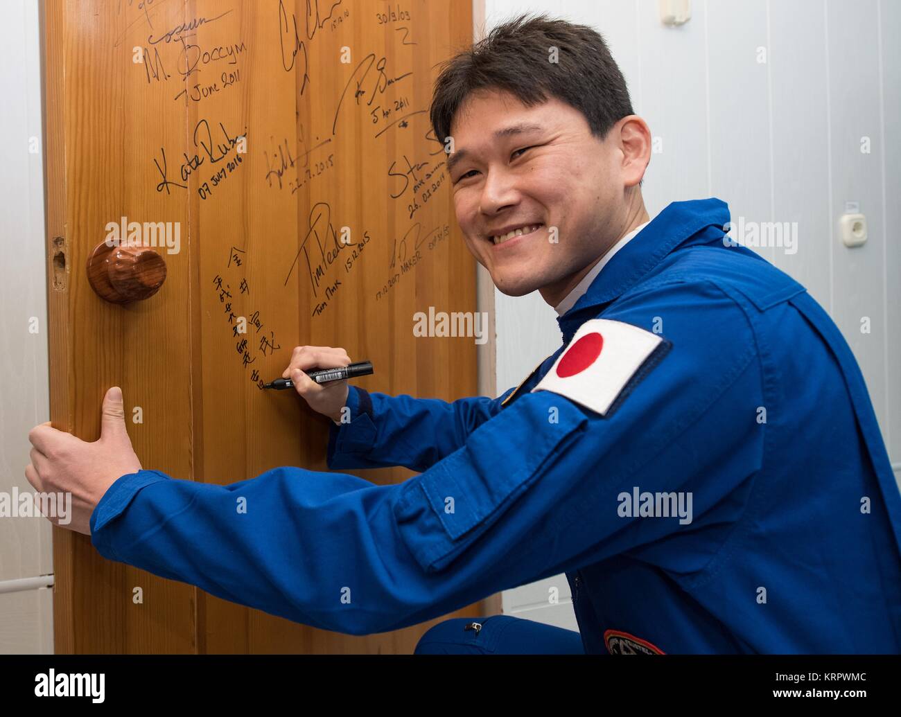 Die NASA ISS Expedition 54 prime Besatzungsmitglied japanische Astronaut Norishige Kanai der Japan Aerospace Exploration Agency (JAXA) unterzeichnet die Tür an der Kosmonaut Hotel vor der Abreise für die Sojus MS-07 Raumfahrzeuge Dezember 17, 2017 in Baikonur, Kasachstan. Stockfoto