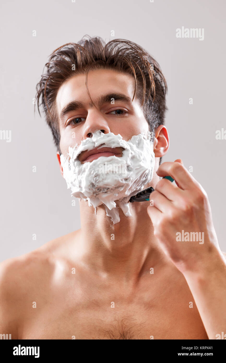 Jungen gutaussehenden Mann ist seinen Bart rasieren. Stockfoto