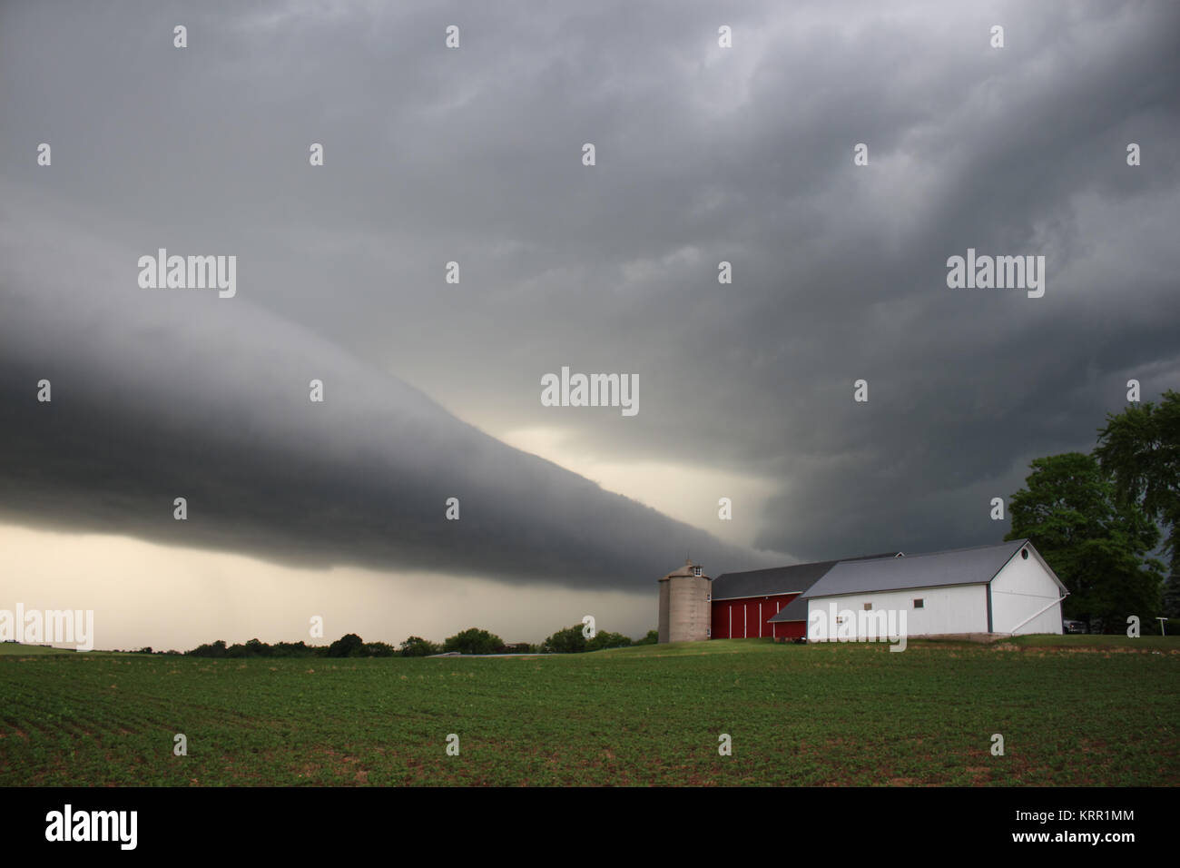 Eine unheimliche Rolle cloud Ansätze eine kleine Farm im mittleren Westen. Stockfoto