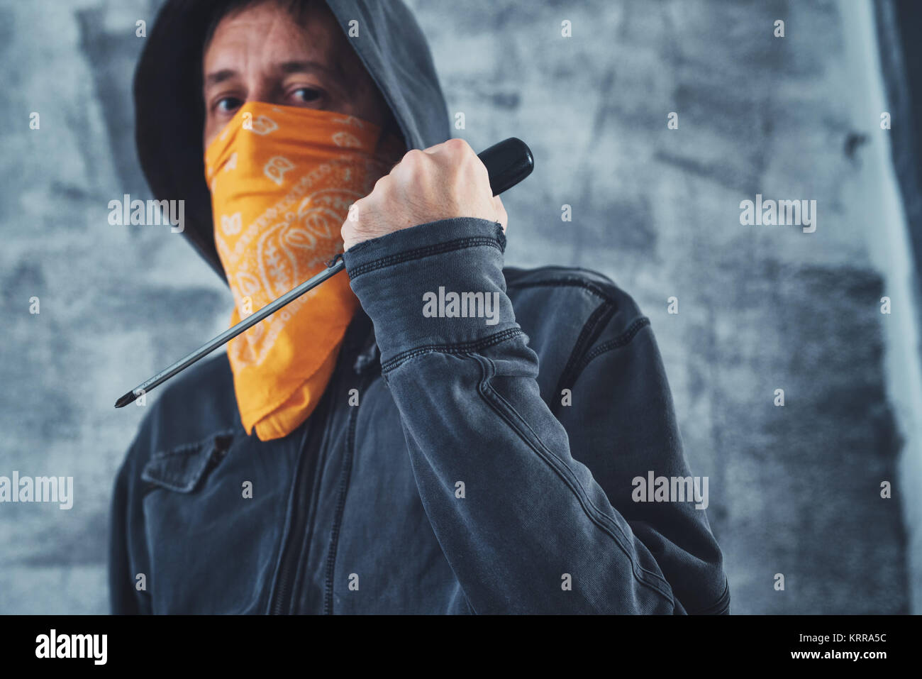 Hooded Bandenmitglieder Kriminelle mit Schal über Gesicht mit Schraubendreher als Waffe Stockfoto