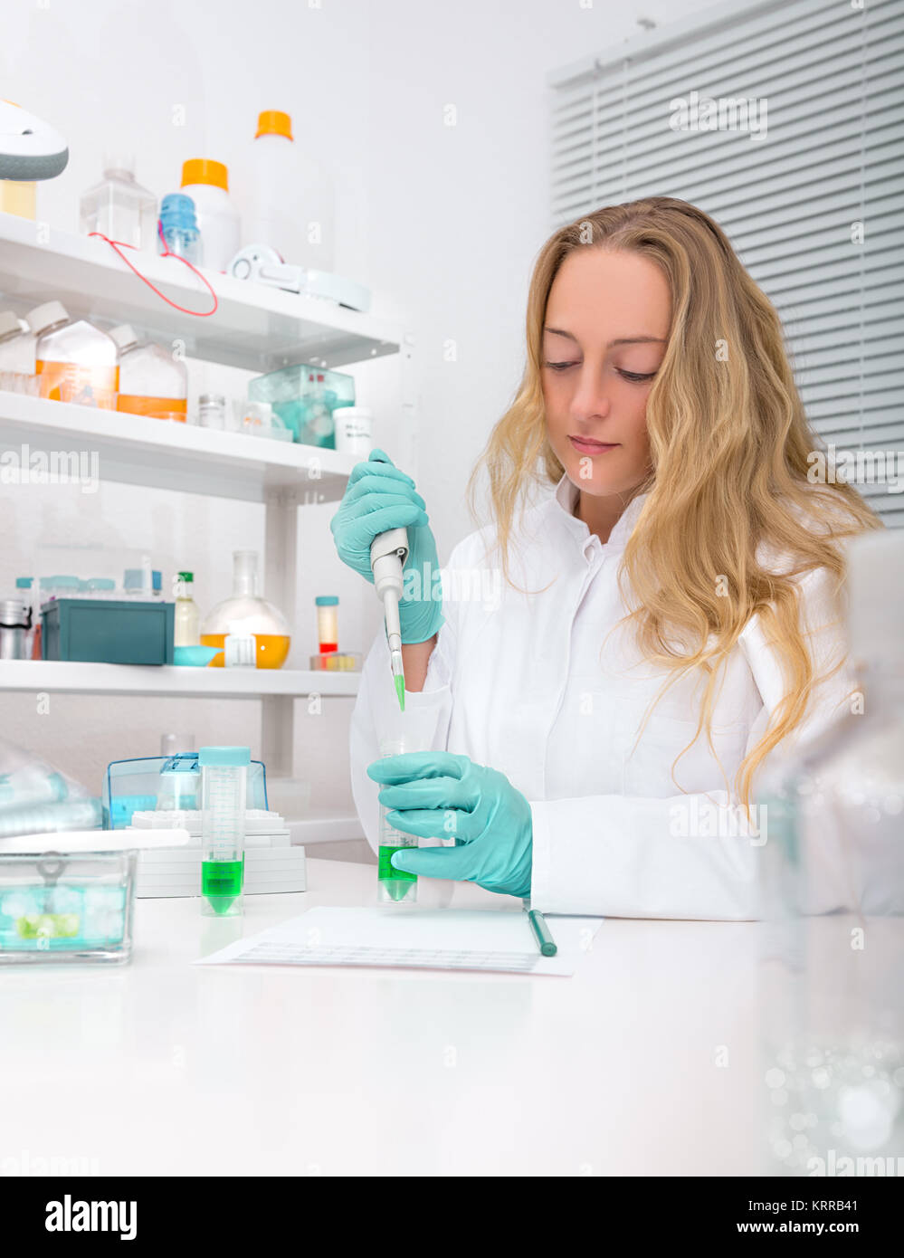 Weiblich Wissenschaftler oder tech Pipetten Probe in ein Reagenzglas im Labor Stockfoto