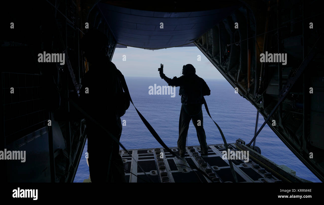 Us Air Force Soldaten für eine Drop Zone von der Rückseite eines C-130J Super Herkules Flugzeug während des Betriebs Weihnachten Drop Dezember 8, 2017 Scan im Pazifischen Ozean. Stockfoto
