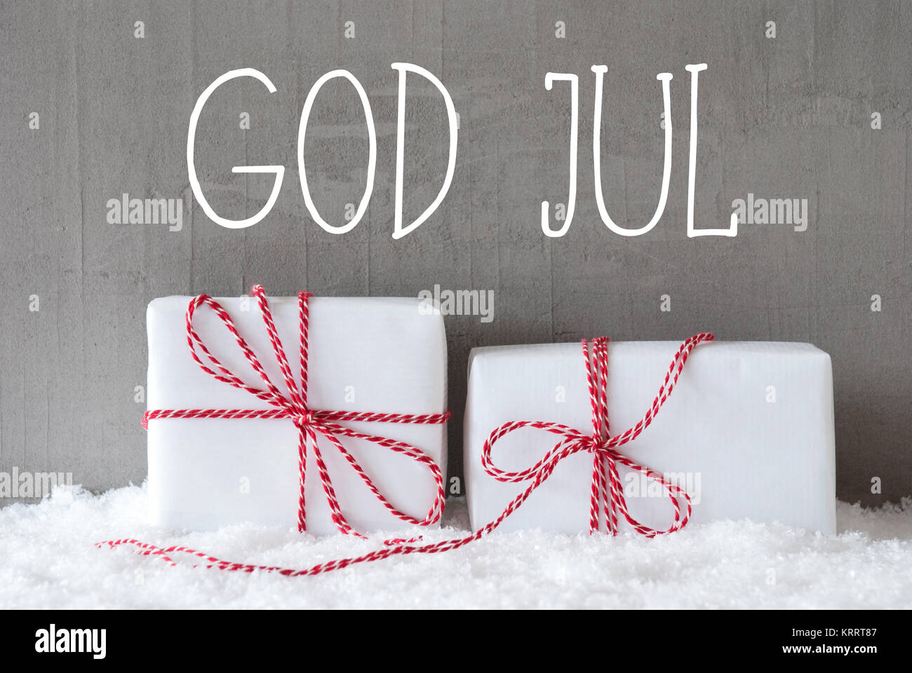 Schwedische Text Gott Aug bedeutet, frohe Weihnachten. Zwei Weiße Weihnachten Geschenke oder Präsentiert auf Schnee. Zement Wand als Hintergrund. Moderne und den urbanen Stil. Stockfoto