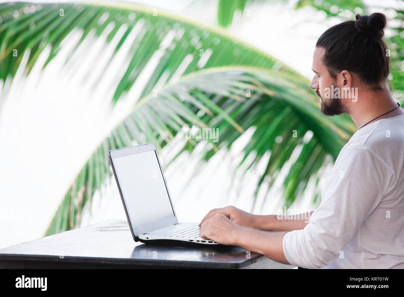 Man entspannt am Strand mit Laptop, Freelancer Arbeitsplatz, Traumjob Stockfoto