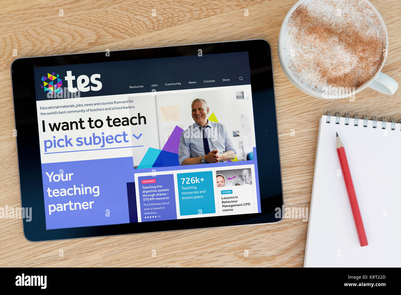 Die TES-Website auf einem iPad Tablet Gerät, das auf einem Tisch liegt neben einem Notizblock und Bleistift und eine Tasse Kaffee (nur redaktionell) Stockfoto
