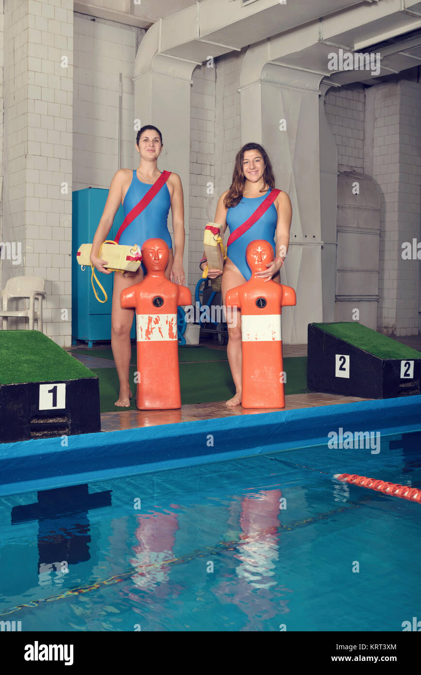 Zwei Trainer mit Trainingspuppe an einem Pool Stockfoto