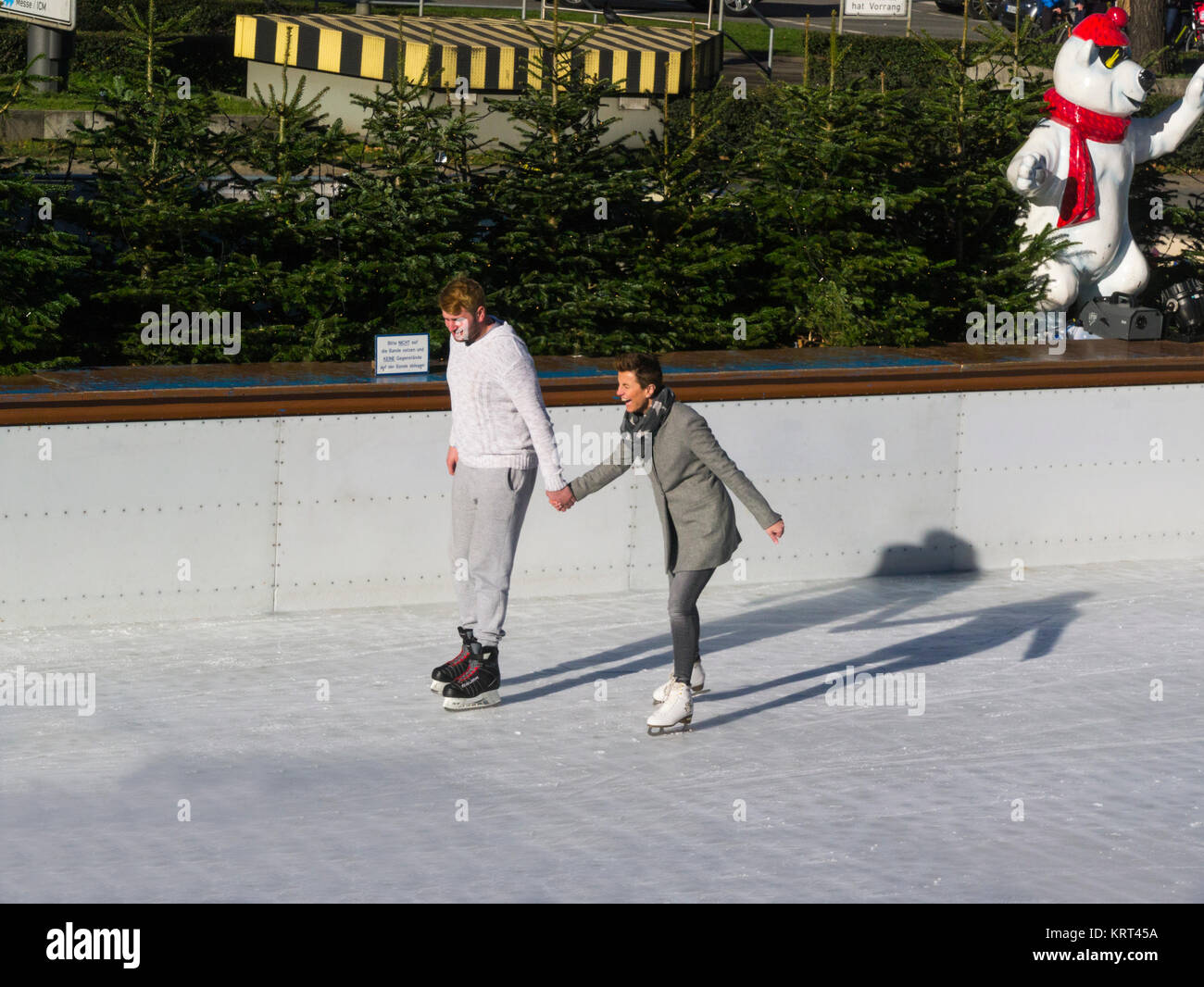 Junge Menschen und Frauen halten sich an den Händen skating Münchener EisZauber München Ice Magic Eisbahn Stachus Karlsplatz München Bayern Deutschland EU Stockfoto