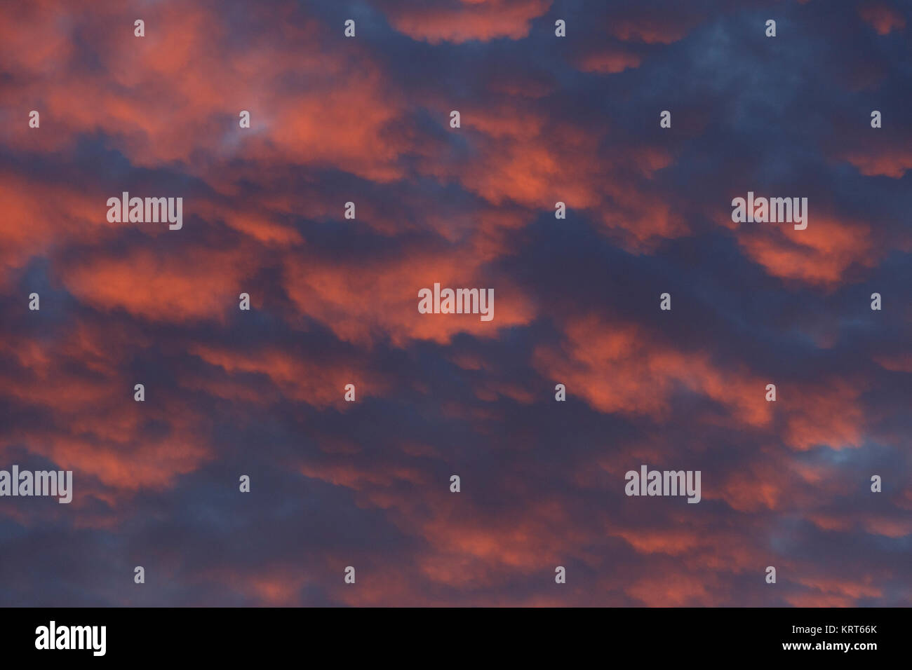 Der Sonnenaufgang ist unter den Wolken sichtbar, die Weiche und rotes Licht in jener Stunde, farbig die Unterseite der Wolken geben Ihnen eine seltene Aspekt. Stockfoto