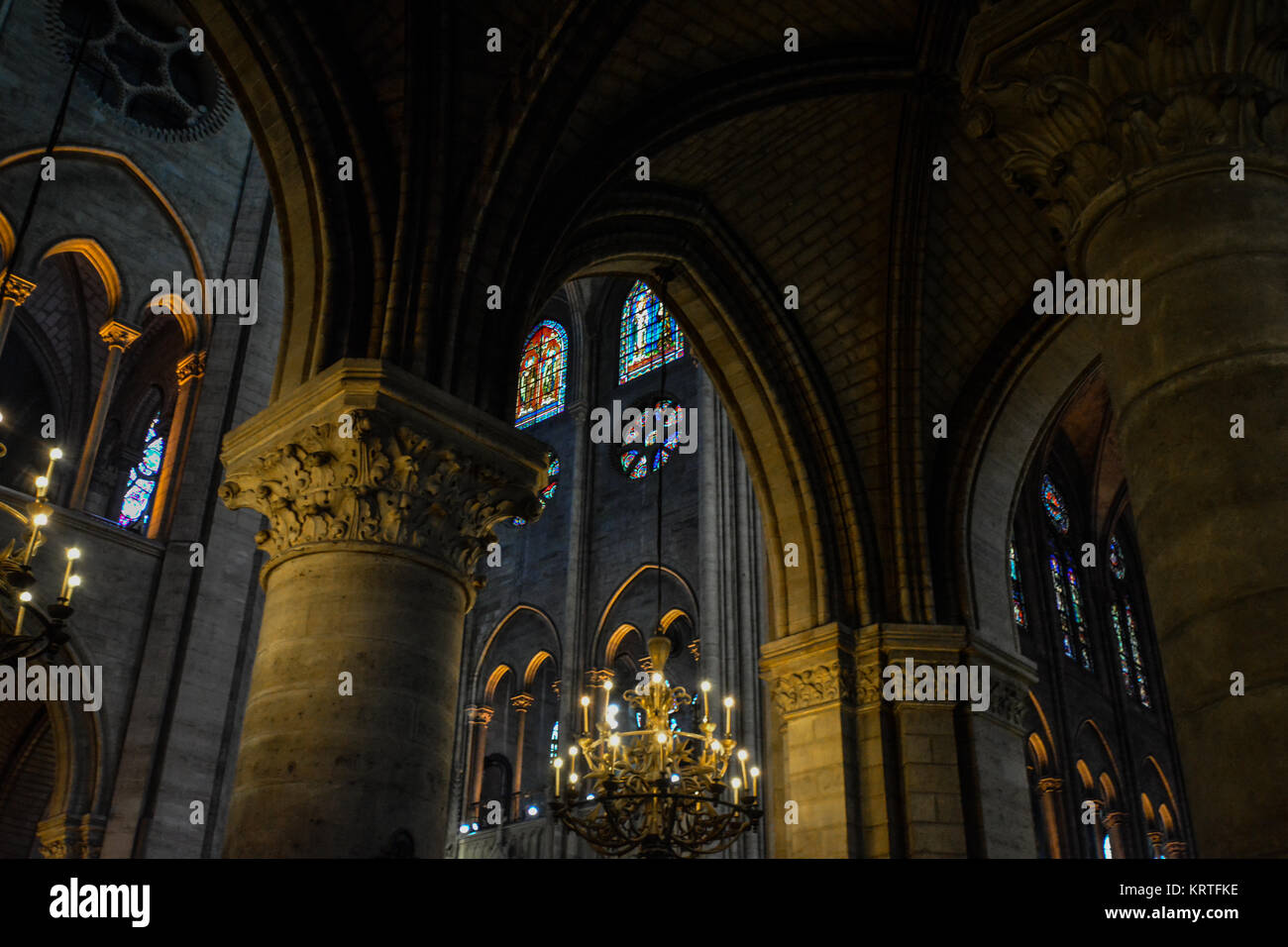 Das Innere der Kathedrale de Notre Dame auf der Ile de la Cite in Paris, Frankreich, mit dramatischer Beleuchtung, Kronleuchter und Buntglasfenster Stockfoto