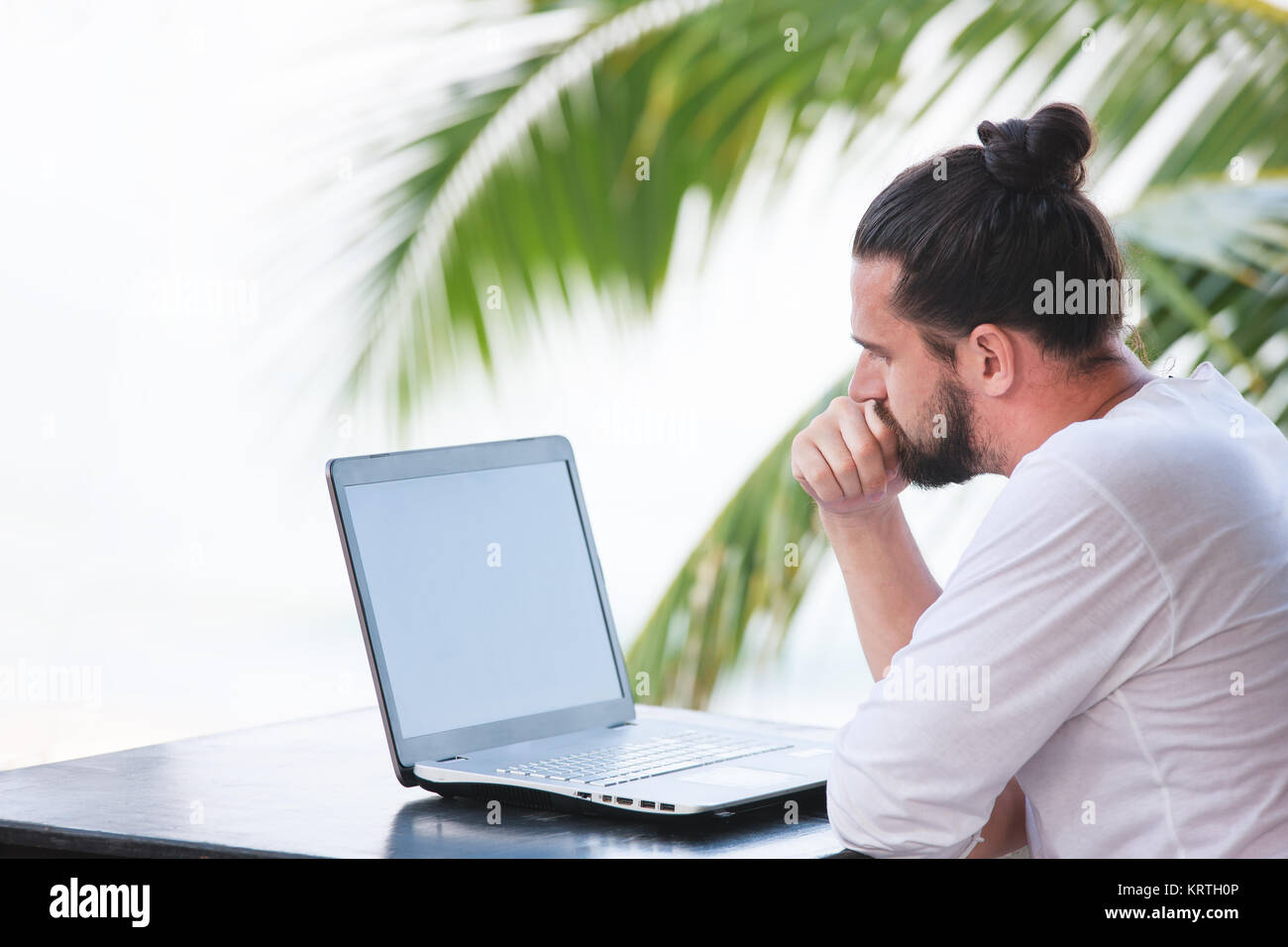 Man entspannt am Strand mit Laptop, Freelancer Arbeitsplatz, Traumjob Stockfoto