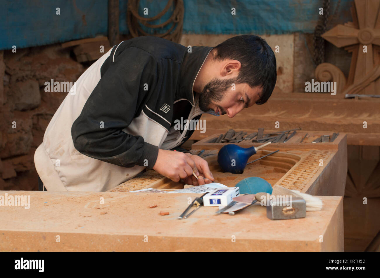 Artisan carving Armenischen khachkar, Jerewan, Armenien, Oktober 2012: Eine junge armenische Artisan schnitzt eine Armenische cross Stein in seiner Werkstatt in Eriwan. Stockfoto
