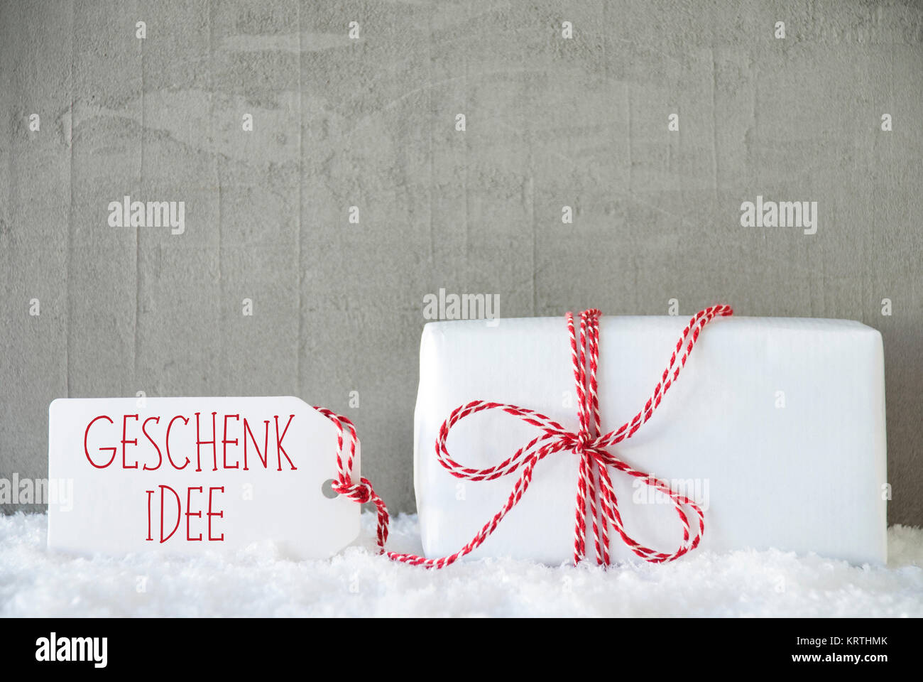 Etikett mit deutschem Text Geschenk Idee bedeutet Geschenk Idee. Ein Weihnachtsgeschenk oder auf Schnee. Zement oder Beton Wand als Hintergrund. Moderne und den urbanen Stil. Stockfoto