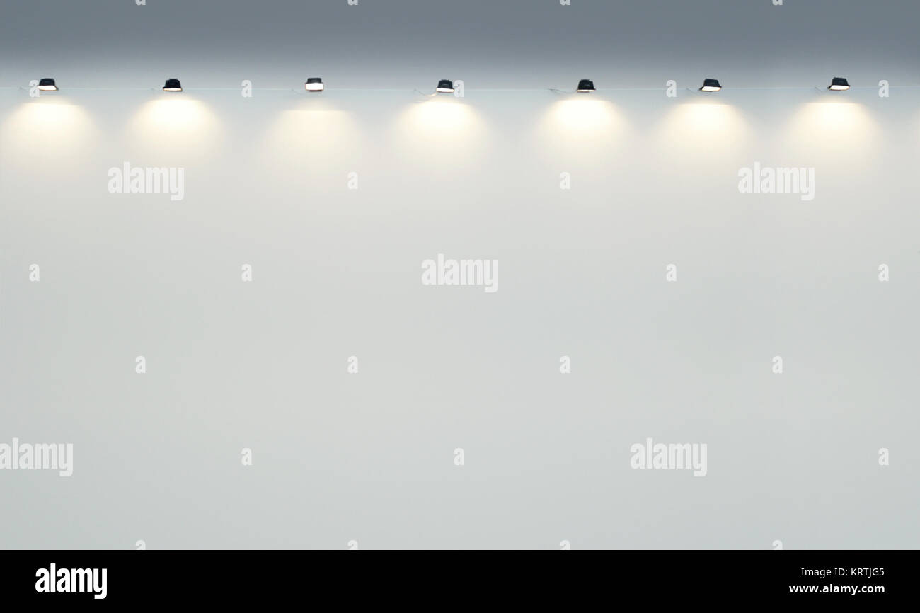 Zusammenfassung Hintergrund einer Wand eines leeren Galerie Wand mit vielen Leuchten Strahler Stockfoto