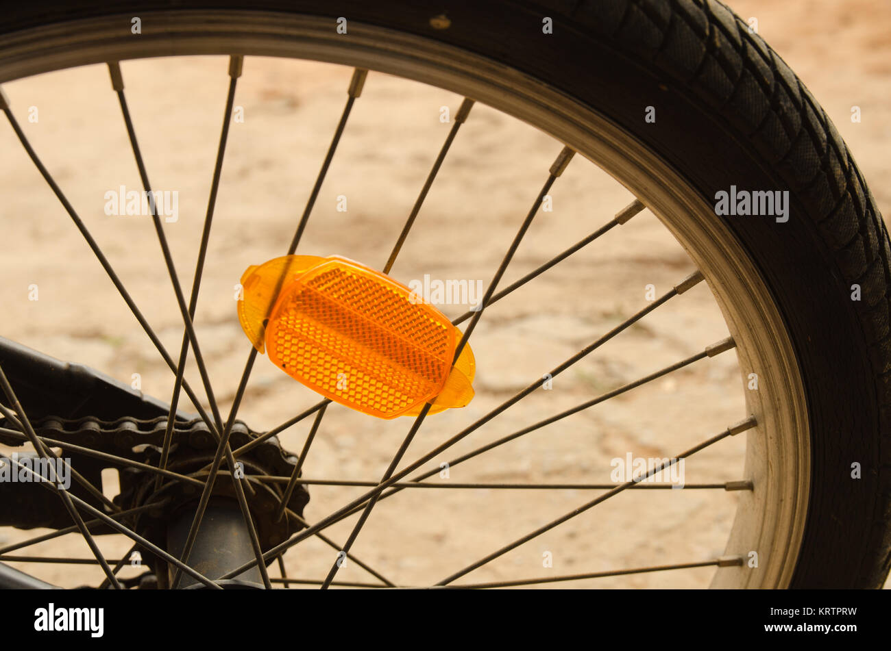 Nahaufnahme von ein Fahrrad-Rad zeigt orange Reflektor und Speichen Stockfoto