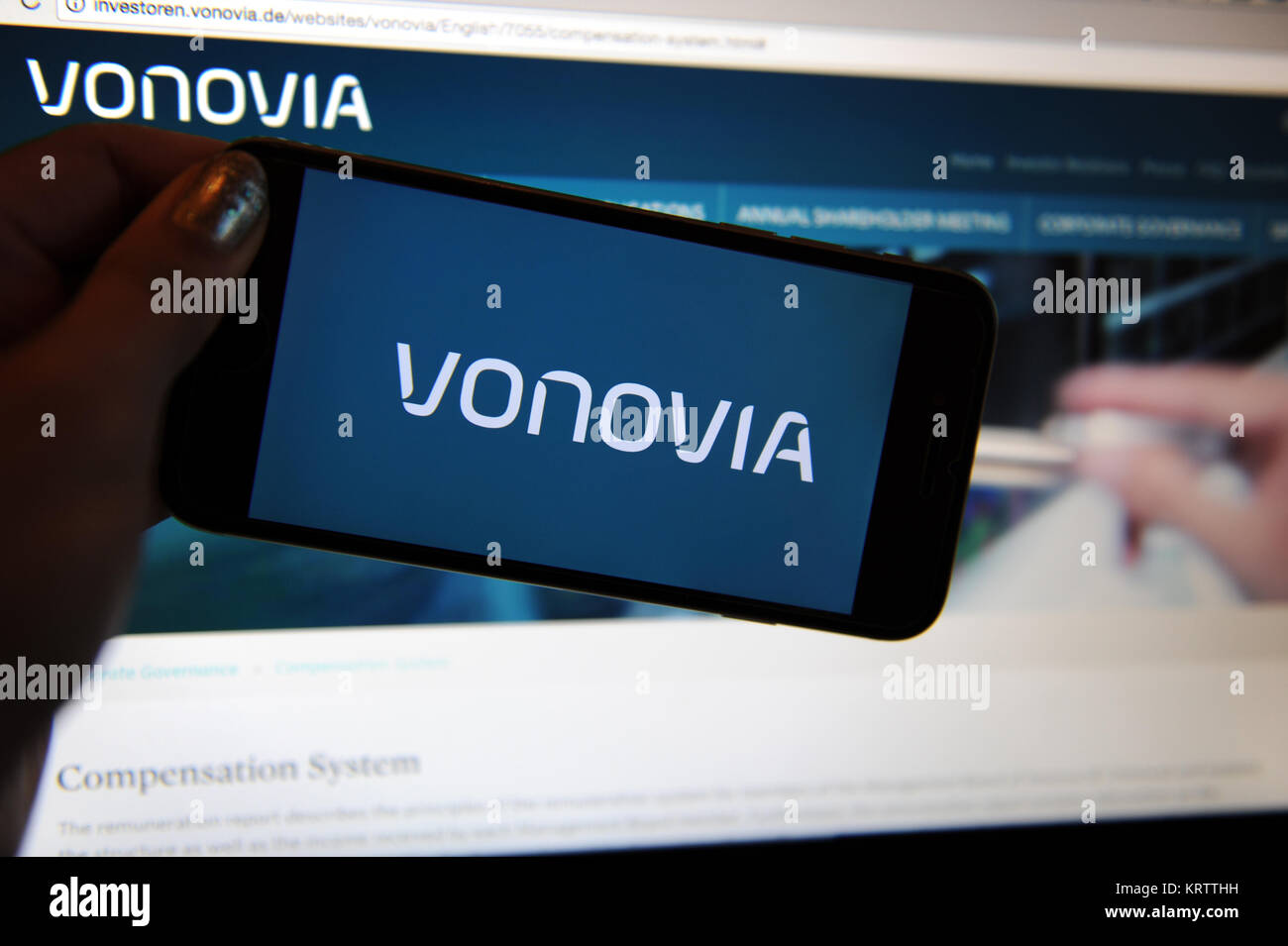Die Vonovia Logo auf ein Telefon und eine Website auf einem Computer Stockfoto