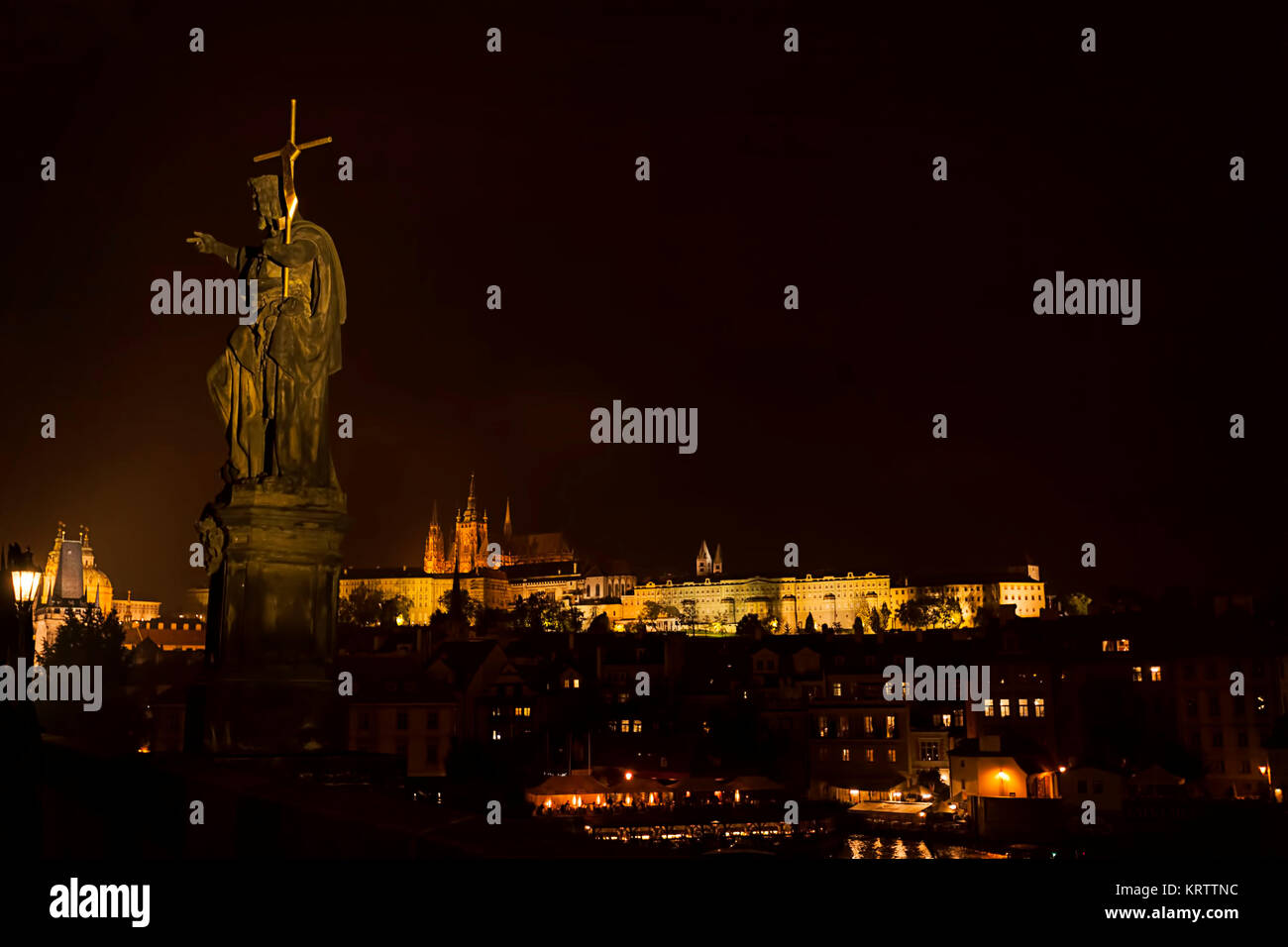 St. Johannes der Täufer Statue auf der Karlsbrücke bei Nacht. Panorama von Prag, tschechische Republik. Schloss, die St. Vitus Kathedrale und Moldau Stockfoto