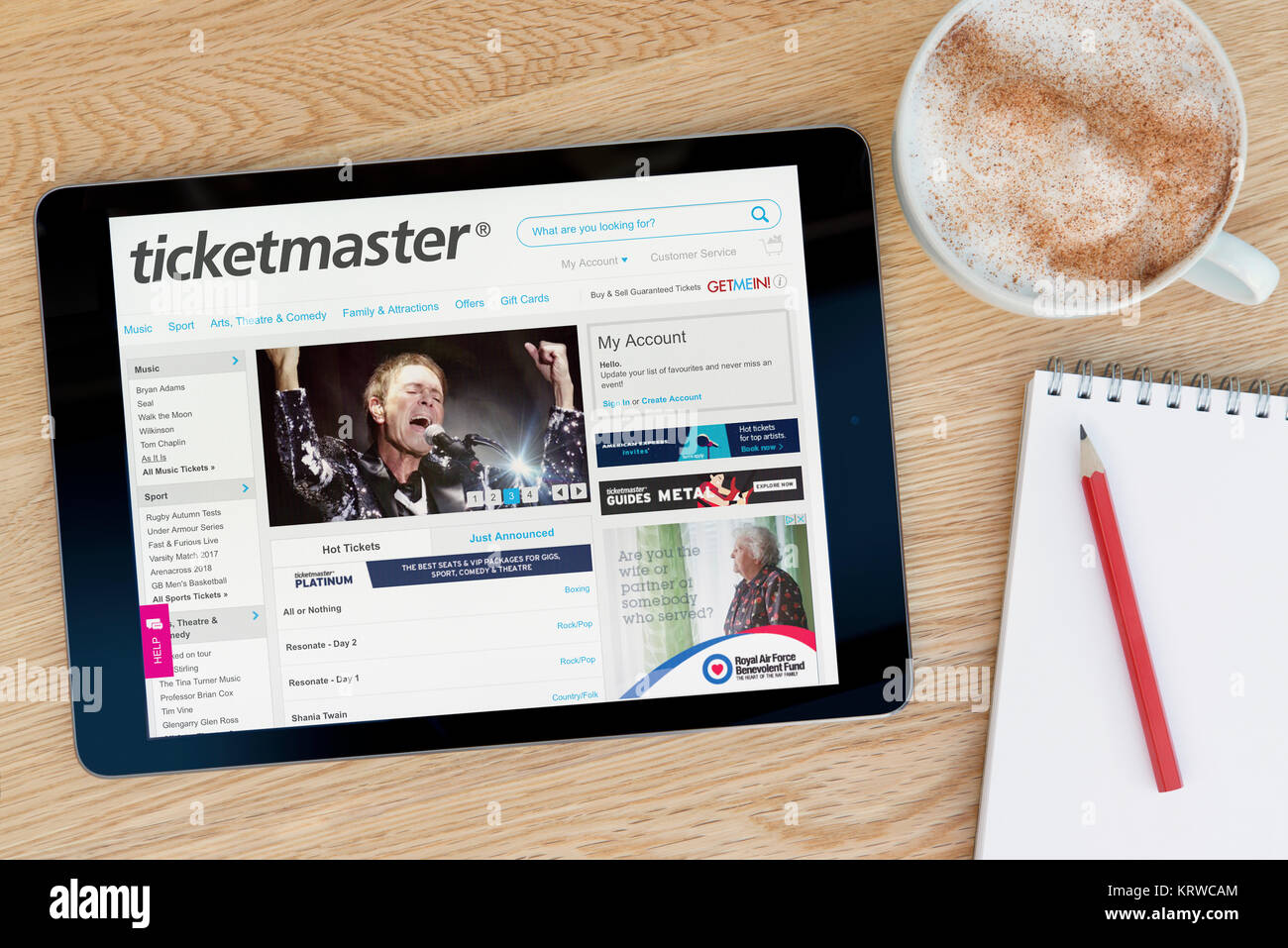 Die Ticketmaster Website auf einem iPad Tablet Gerät, das auf einem Tisch liegt neben einem Notizblock und Bleistift und eine Tasse Kaffee (nur redaktionell) Stockfoto