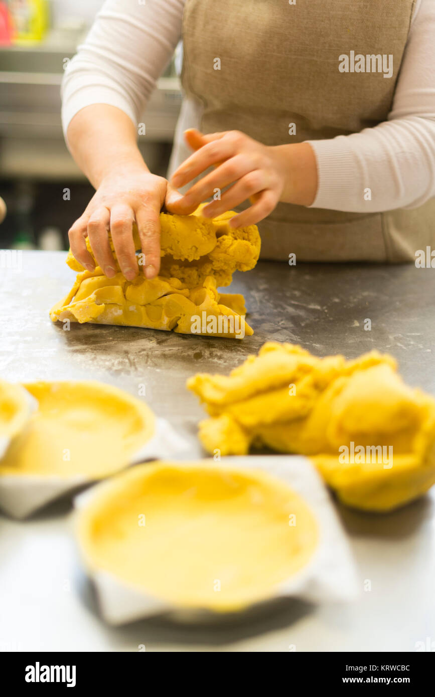 Chef Gebäck Bäcker Frau Vorbereitung und Ausarbeitung der dought mit Eiern Olivenöl Mehl Salz und Wasser für die Schaffung von Kuchen Cookies und Süßigkeiten gemacht. Stockfoto