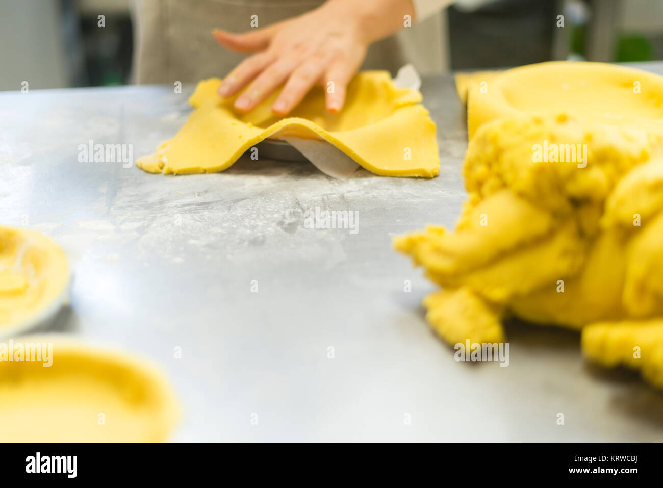 Chef Gebäck Bäcker Frau Vorbereitung und Ausarbeitung der dought mit Eiern Olivenöl Mehl Salz und Wasser für die Schaffung von Kuchen Cookies und Süßigkeiten gemacht. Stockfoto