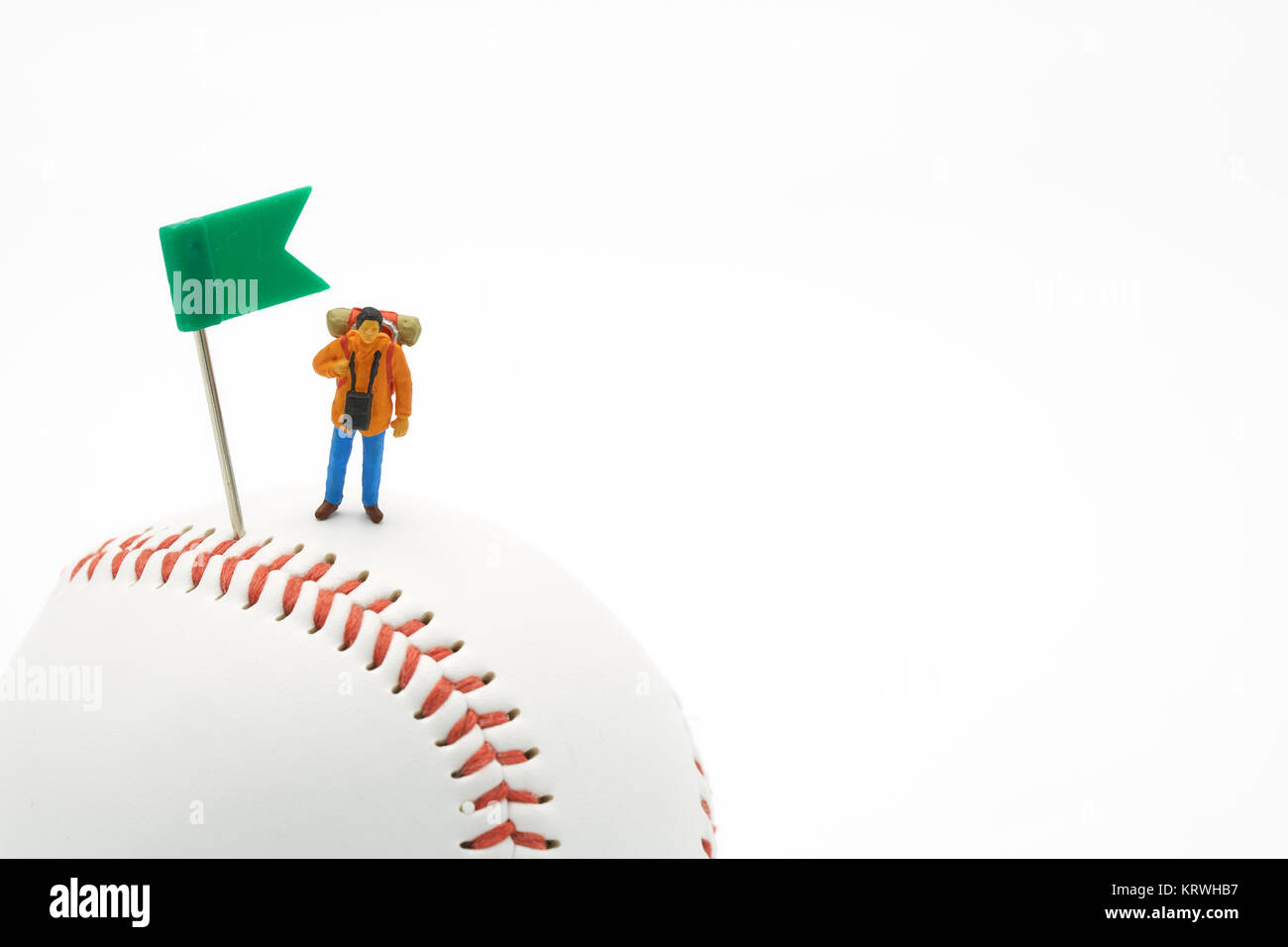 Miniatur Leute stehen mit der grünen Flagge Pin auf Baseball auf einen weißen Hintergrund und roten Ziernähten Baseball. Als Hintergrund Travel Concept und Business Stockfoto