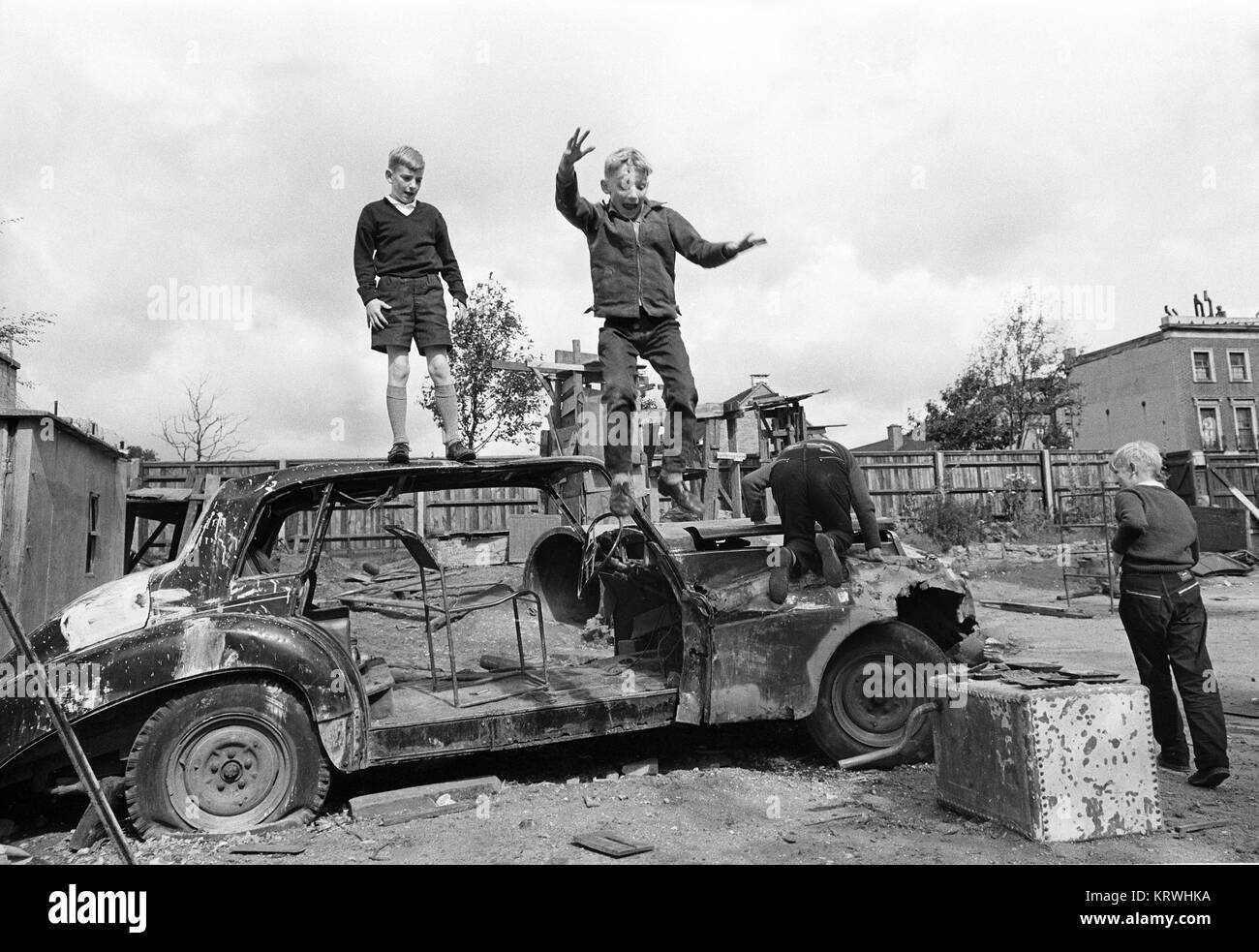 Drei Kinder spielen mit dem Auto Wreckage, England, Großbritannien Stockfoto