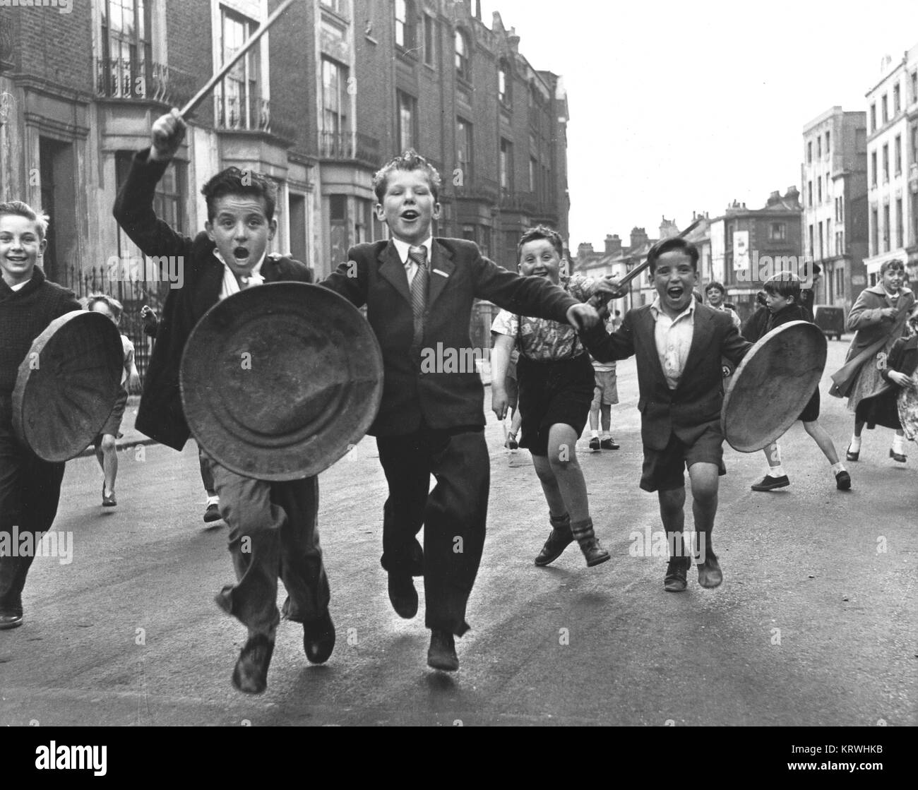 Kinder mit Schirm und Stock spielen Ritter, England, Großbritannien Stockfoto