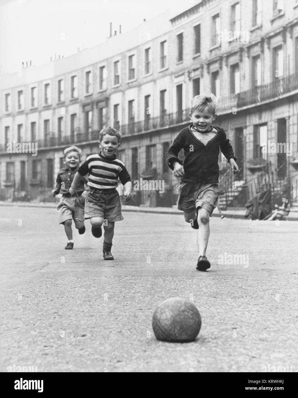 Kinder spielen Fußball auf der Straße, 50er Jahre, England, Großbritannien Stockfoto