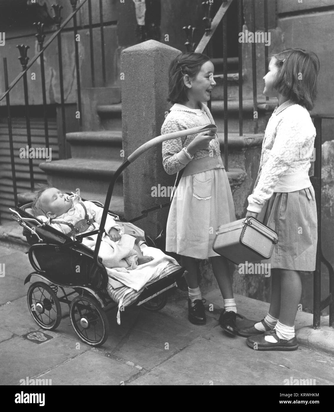 Zwei Mädchen mit Baby und Kinderwagen, England, Großbritannien Stockfoto
