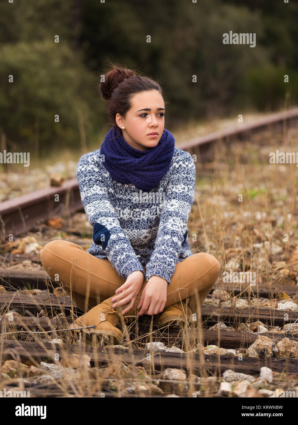 Junge Frau sitzt auf der alten Eisenbahn Stockfoto