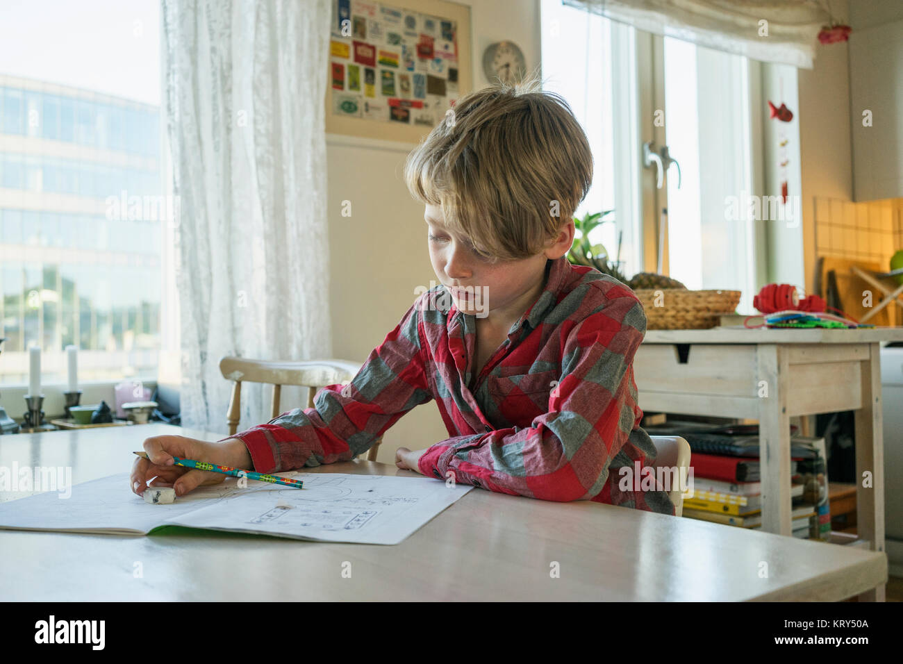Ein kleiner Junge an einem Tisch sitzen zeichnen Stockfoto