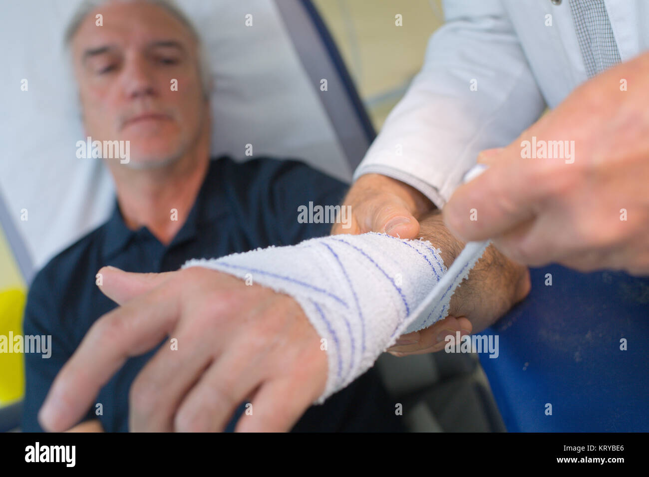 Arzt seine Patienten Hand in Arztpraxis Bandagierung Stockfoto